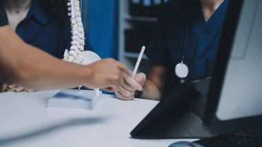 Doktor hastayı bilgisayarda muayene ediyor.