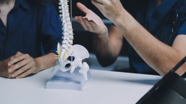 Doktor klinikte insan iskeleti modeli tutuyor..