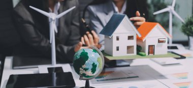 Geri dönüşüm planlayan ve tartışan iş adamları ofis toplantı odasında yeniden kullanım politikası sembolünü azalttı.