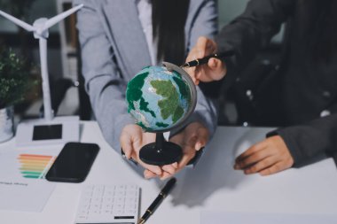 Geri dönüşüm planlayan ve tartışan iş adamları ofis toplantı odasında yeniden kullanım politikası sembolünü azalttı.