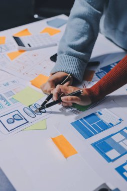 UX UI tasarımcısı prototipi bir telefon üzerinde test ediyor, web sitesi ve mobil uygulama tasarım konseptinde bir web sitesi ve mobil uygulama prototipi için telgraflar üzerinde tartışıyor ve beyin fırtınası yapıyor.