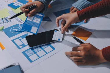 UX UI tasarımcısı prototipi bir telefon üzerinde test ediyor, web sitesi ve mobil uygulama tasarım konseptinde bir web sitesi ve mobil uygulama prototipi için telgraflar üzerinde tartışıyor ve beyin fırtınası yapıyor.