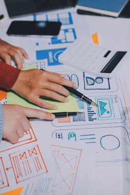 UX UI tasarımcısı prototipi bir telefon üzerinde test ediyor, web sitesi ve mobil uygulama tasarım konseptinde bir web sitesi ve mobil uygulama prototipi için telgraflar üzerinde tartışıyor ve beyin fırtınası yapıyor.