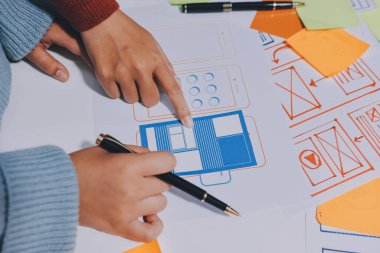 UX UI tasarımcısı prototipi bir telefon üzerinde test ediyor, web sitesi ve mobil uygulama tasarım konseptinde bir web sitesi ve mobil uygulama prototipi için telgraflar üzerinde tartışıyor ve beyin fırtınası yapıyor.