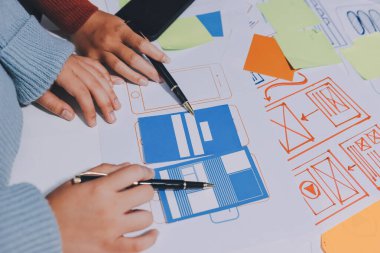 UX UI tasarımcısı prototipi bir telefon üzerinde test ediyor, web sitesi ve mobil uygulama tasarım konseptinde bir web sitesi ve mobil uygulama prototipi için telgraflar üzerinde tartışıyor ve beyin fırtınası yapıyor.