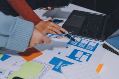 UX UI tasarımcısı prototipi bir telefon üzerinde test ediyor, web sitesi ve mobil uygulama tasarım konseptinde bir web sitesi ve mobil uygulama prototipi için telgraflar üzerinde tartışıyor ve beyin fırtınası yapıyor.