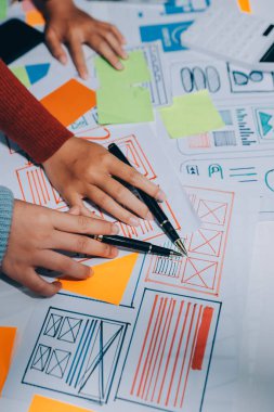 UX UI tasarımcısı prototipi bir telefon üzerinde test ediyor, web sitesi ve mobil uygulama tasarım konseptinde bir web sitesi ve mobil uygulama prototipi için telgraflar üzerinde tartışıyor ve beyin fırtınası yapıyor.