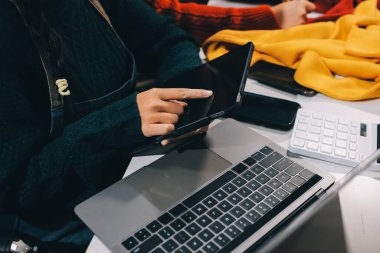 Küçük işletmeler kurma portresi KOBİ sahipleri ve iki Asyalı kadın online siparişleri kontrol ediyor. Ev işlerinde çalışan kutucuklarla çalışan ürünleri satıyorlar.