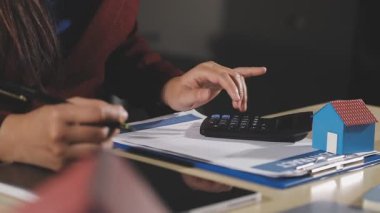 Hesap makinesiyle çalışan genç bir kadın.
