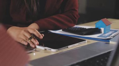 Masada otururken tablet ve bilgisayar kullanan genç bayan tasarımcı