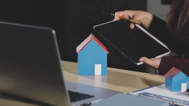 İş kadını yeni gayrimenkul için dizüstü bilgisayar kullanıyor.