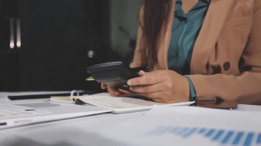 İş kadını hesap makinesi kullanıyor ve masadaki verileri hesaplıyor. muhasebe, yatırım ve mali konsebe