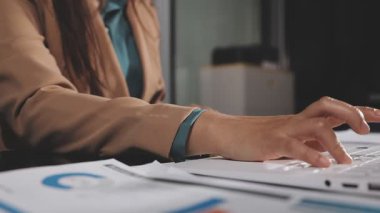 Ofisinde dizüstü bilgisayarı olan genç bir iş adamı.