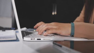 Bilgisayarıyla ofisinde çalışan genç bir kadın.