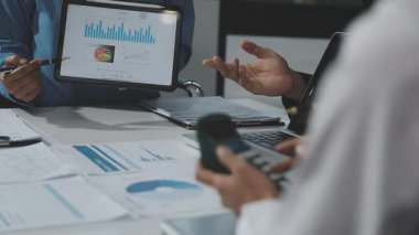 Ofiste finansal grafik ve tablet bilgisayarla çalışan iş adamı