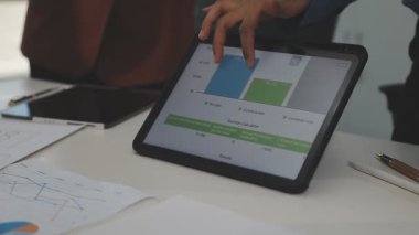 Finansal istatistikleri olan tablet bilgisayar kullanan işadamı