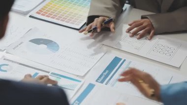 İş adamları masadaki mali tabloları tartışıyor ve analiz ediyorlar..