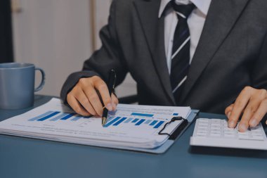 Muhasebe bankacılığı konsepti. Finans işleriyle ilgilenen bir iş kadını ve ofis masraflarını hesaplayan bir masa. Hesap makinesi ve mali muhasebe kullanan bir kadın..