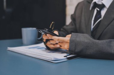 Asyalı iş adamı cep telefonu kullanıyor. Sohbet etmek, SMS yazmak veya sunum yapmak.