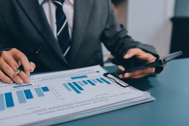 Asyalı iş adamı cep telefonu kullanıyor. Sohbet etmek, SMS yazmak veya sunum yapmak.