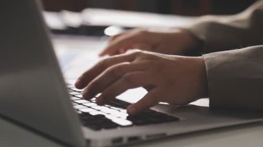 Genç iş adamı ofiste dizüstü bilgisayar kullanıyor.