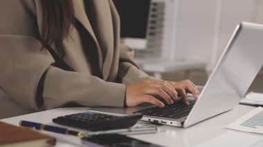 İş yerinde dizüstü bilgisayar kullanan bir kadın.