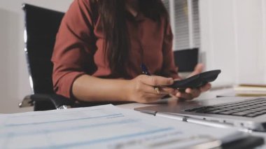 Ofiste bilgisayar ve hesap makinesi kullanan iş kadını