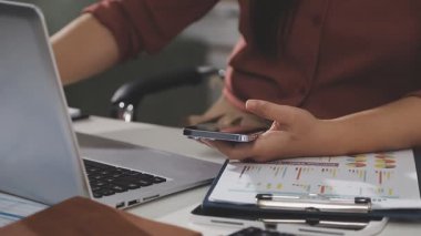 Ofiste çalışırken tablet ve laptop kullanan genç bir iş kadını.