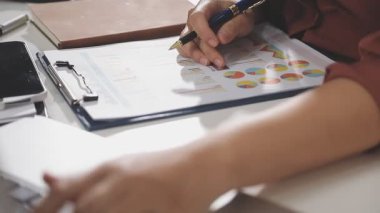 İş kadını eli defterin üzerinde kalem kullanıyor..