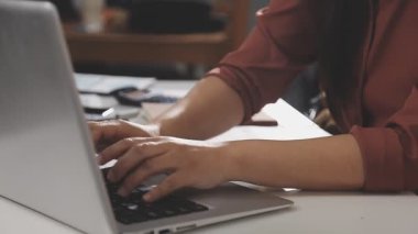 Dizüstü bilgisayarda çalışan genç bir kadın..