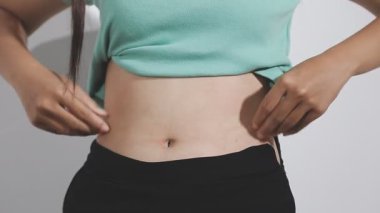 Karın ağrısı, karın ağrısı, beyaz arka planda izole edilmiş genç bir kadın.