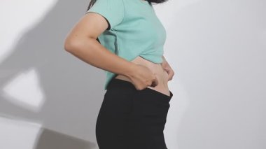 Genç Asyalı kadın karın ağrısı çekiyor. sağlık sorunu