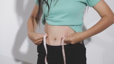 Genç Asyalı kız belini ölçüyor..