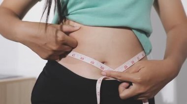Şişman göbeğini ölçen kadın. diyet kavramı