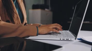 businesswoman working on laptop at home office.
