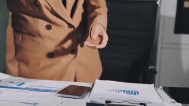 Mavi gömlekli iş kadını ofiste yazıyor..