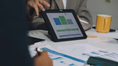 Ofiste dijital tablet ve bilgisayarla çalışan iş adamı