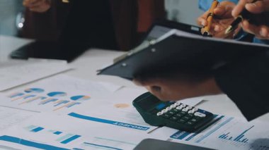 Hesap makinesini işaret eden işadamının elini kapat ve ofisteki kağıda rapor yaz