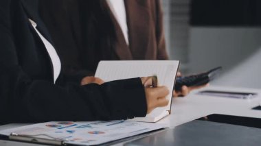 İş kadını ofiste deftere notlar yazıyor.