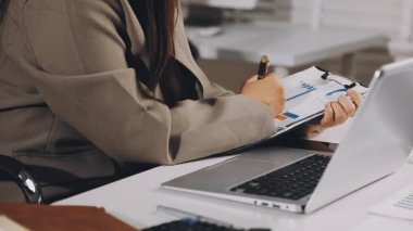 Ofisinde dizüstü bilgisayarı olan takım elbiseli genç bir kadın.