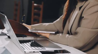 Modern oturma odasında dizüstü bilgisayarla çalışan bir kadın. Ofiste dizüstü bilgisayarda çalışan serbest çalışan bir kadın..