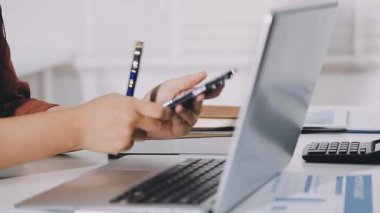 Modern ofiste akıllı telefon kullanan bir kadın. Laptop, akıllı telefon, stok fotoğrafı.