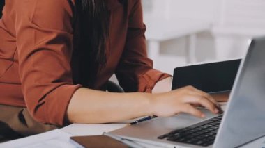 İş kadını bilgisayarda çalışıyor ve akıllı telefon kullanıyor..