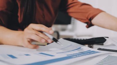 İş planlarını analiz etmek için hesap makinesi kullanan iş kadınlarının kapatılması ve evdeki bilgisayardaki finansal verilerin analiz edilmesi.