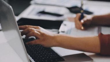 Ofiste dizüstü bilgisayar üzerinde çalışan iş adamı.