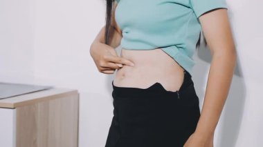 Karın ağrısı çeken genç bir kadın.