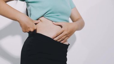 Beyaz arka planda karnı ağrıyan Asyalı bir kız.