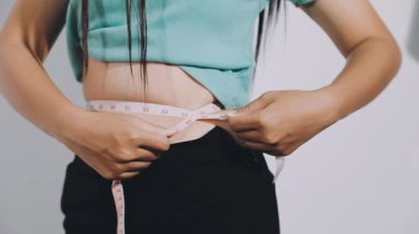 Belini ölçen genç bir kadın.
