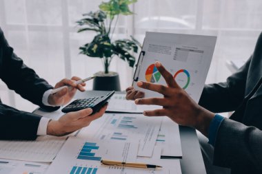 Muhasebe şirketi kazançlı nakit akışı için finansman ve vergilendirme planlaması, ofiste çalışan denetçi ve muhasebeci ekibi, mali verileri ve muhasebe kayıtlarını hesap makinesiyle analiz eder.