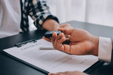 Araba satıcısı, satın alma sözleşmesini yasal olarak imzalayan müşterilere anahtar verdi, araba satışlarının başarıyla tamamlanması, satın alma sözleşmesi ve anahtar teslimatı..